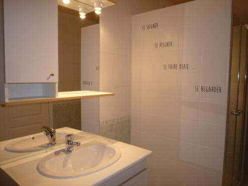 y baño con lavabo y espejo. en L'IF Charmante petite maison bretonne, en Scrignac