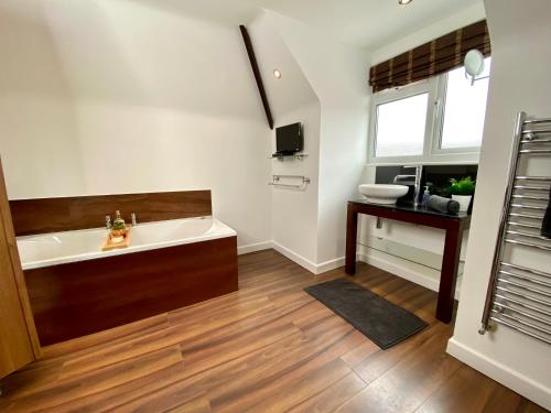 a large bathroom with a tub and a sink at Lovely house in a great location with Parking, WiFi & Smart TV - Near Poole & Bournemouth in Poole