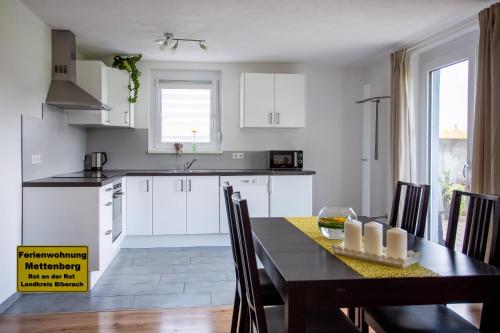 a kitchen and dining room with a table and chairs at Ferienwohnung Mettenberg in Rot an der Rot