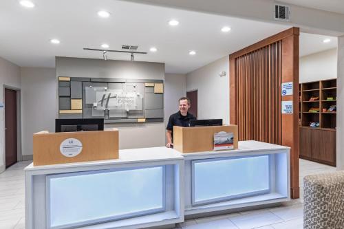 a man is standing at a counter in a lobby at Holiday Inn Express Hotel & Suites Vidor South by IHG in Vidor