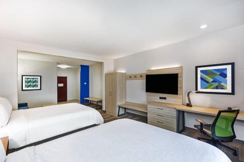 a hotel room with two beds and a desk with a television at Holiday Inn Express Hotel & Suites Vidor South by IHG in Vidor