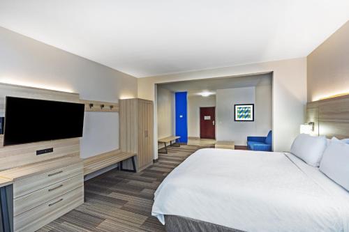 a hotel room with a bed and a flat screen tv at Holiday Inn Express Hotel & Suites Vidor South by IHG in Vidor