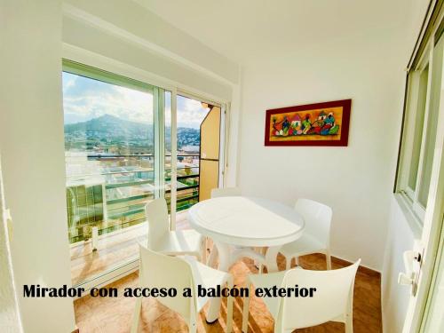 a white table and chairs in a room with a window at Labradores 3 dormitorios in Peñíscola