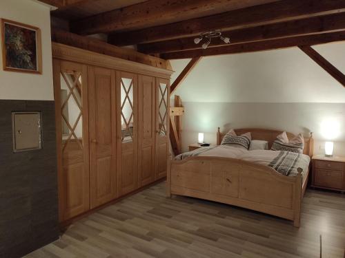 a bedroom with a large bed and wooden walls at Sonnige Zimmer in Eberhardzell