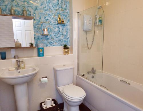 a bathroom with a toilet and a sink and a shower at The Heathers - near beach & free golf bag & clubs. in Maybole