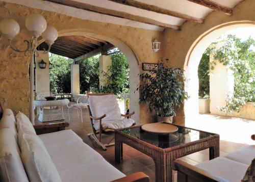 ein Wohnzimmer mit einem Sofa und einem Tisch in der Unterkunft Casa rural con encanto, 4 hab con 4 baños completos en suite, piscina y campo privado in Pedreguer