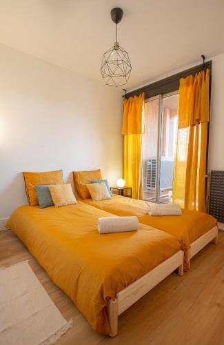 - une chambre avec un grand lit et des rideaux jaunes dans l'établissement Le Champollion - Clim - Gare - Garage - Balcon, à Albi