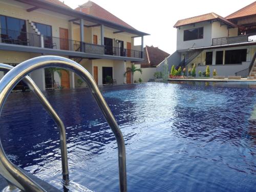 a swimming pool in front of a house at Antari Hotel Pemuteran in Pemuteran