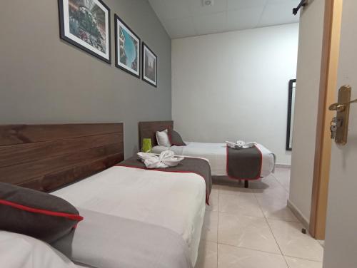 una habitación de hotel con 2 camas y una silla en CH Murallas II, en Madrid