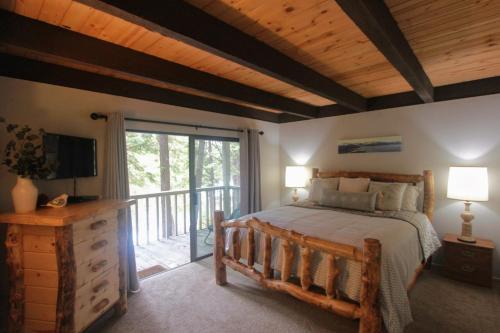 1 dormitorio con 1 cama grande y balcón en Woodsy retreat near Northstar & lake en Kings Beach