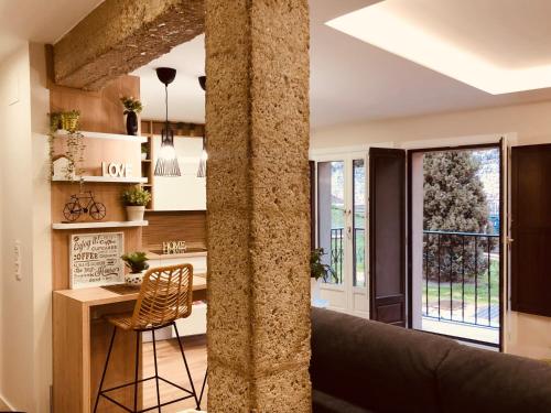 a kitchen with a pillar and a table and a chair at EL CAPRICHO DEL ARCO_Apartamentos Burgos Catedral in Burgos