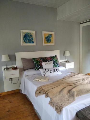 a bedroom with a large white bed and two lamps at Casita de madera in Oberá