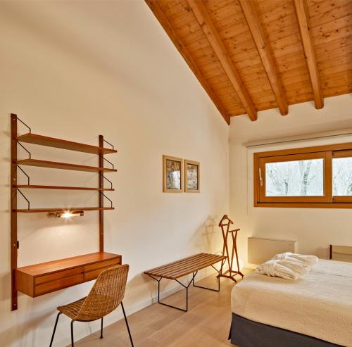 a bedroom with a bed and a desk and a table at Al Canton Agriturismo di Design in San Michele al Tagliamento