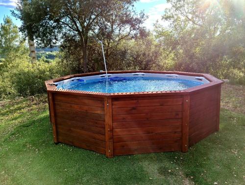 a hot tub in the grass in a yard at Cal Viudet Nou in Caserras
