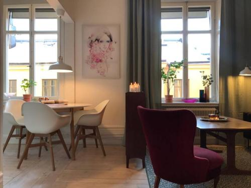 a living room with a dining room table and chairs at Bohemian and light one room apartment in SoFo 31sqm in Stockholm