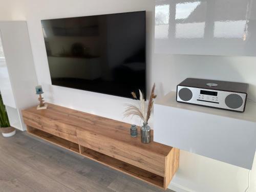 a flat screen tv on a white wall at Luv-Moderne Neubauwohnung in Strandnähe-Wallbox in Wremen