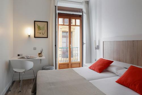 a bedroom with a bed and a table and a sink at Hotel Santa Rosa, Blue Hoteles in Gijón