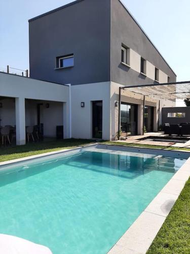 une piscine devant une maison dans l'établissement Villa au cœur des montagnes, à Saint-Étienne-de-Serres