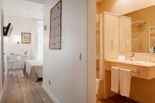 a bathroom with a sink and a mirror at Hotel Santa Rosa, Blue Hoteles in Gijón