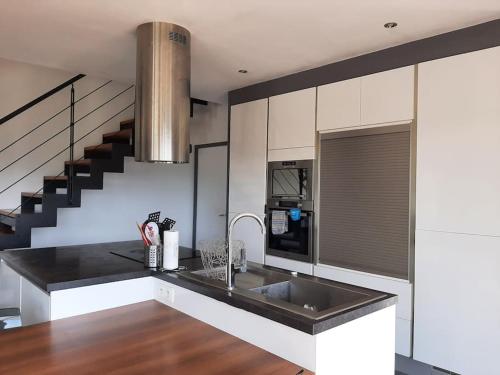 una cucina con lavello e fornello forno superiore di Villa au cœur des montagnes a Saint-Étienne-de-Serres