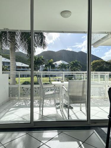 a balcony with a table and chairs and a view at Le Domaine Anse Marcel Beach Resort in Anse Marcel 