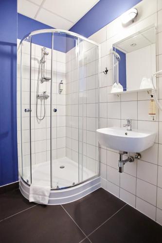 a bathroom with a shower and a sink at Koszary Arche Hotel in Góra Kalwaria