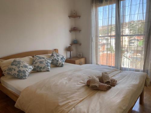 a bed with two towels on it with a window at Apartman Bojanic in Podgorica