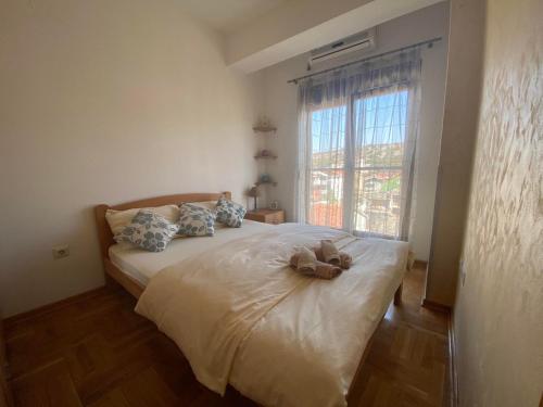 a bedroom with a bed with a teddy bear on it at Apartman Bojanic in Podgorica