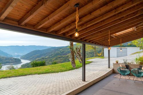 a patio with a view of a river and mountains at Refúgio do Jugo in Vieira do Minho
