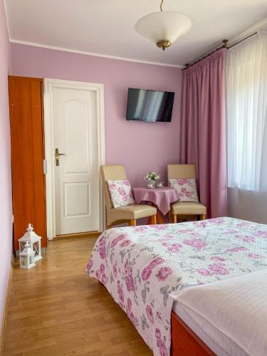 a bedroom with a bed and two chairs and a table at U Macieja z kortem tenisowym in Kłodzko