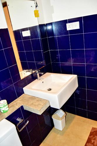a bathroom with a white sink and blue tiles at Wellé Wadiya Beach Villa in Kalpitiya