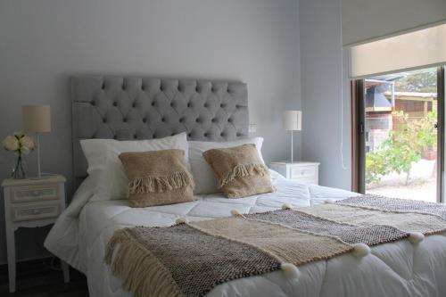 a bedroom with a large white bed with two pillows at Cabañas Sacramento in La Torre