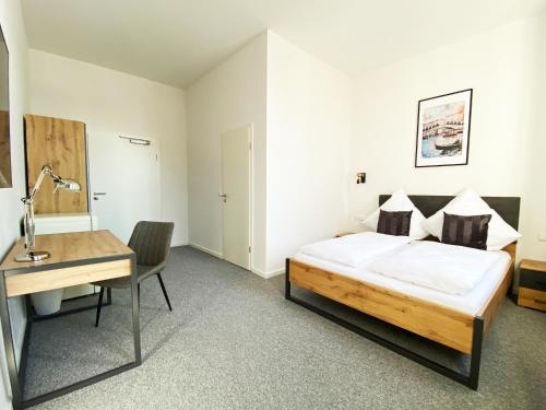- une chambre avec un lit et un bureau dans l'établissement Best Boarding House, à Hanau