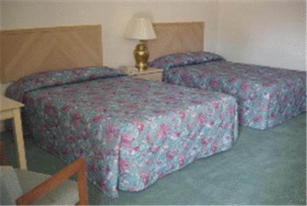 2 camas en una habitación de hotel con mesa en Prestige Inn, en Lafayette