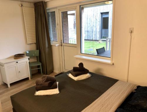 1 dormitorio con 1 cama con 2 toallas en Strandappartement De Ark, en Zoutelande