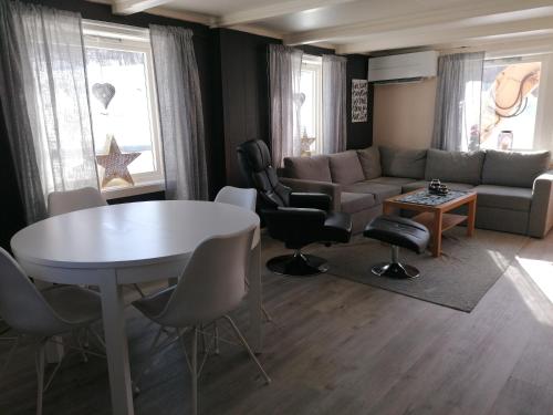 a living room with a couch and a table and chairs at Sommerstue Hessdalen in Ålen