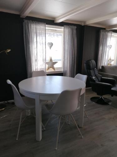 a white table and chairs in a room with a window at Sommerstue Hessdalen in Ålen