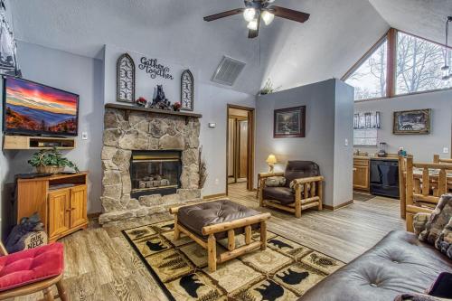 a living room with a large stone fireplace at Adalynn's Mountain Retreat-Hot Tub, Cozy Cabin Retreat in the Smokies Comfort & Fun for All in Pigeon Forge