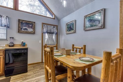 a kitchen and dining room with a wooden table at Adalynn's Mountain Retreat-Hot Tub, Cozy Cabin Retreat in the Smokies Comfort & Fun for All in Pigeon Forge