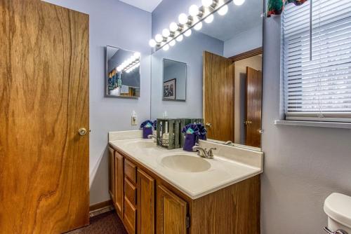 a bathroom with a sink and a mirror at Adalynn's Mountain Retreat-Hot Tub, Cozy Cabin Retreat in the Smokies Comfort & Fun for All in Pigeon Forge