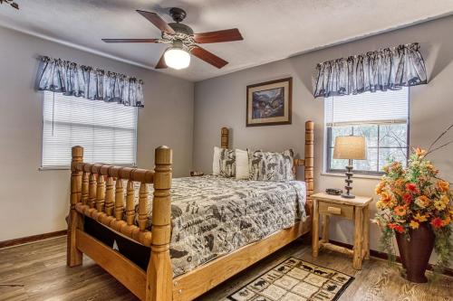 a bedroom with a bed and a ceiling fan at Adalynn's Mountain Retreat-Hot Tub, Cozy Cabin Retreat in the Smokies Comfort & Fun for All in Pigeon Forge