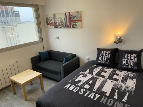 une chambre avec un lit, une chaise et une fenêtre dans l'établissement Studio entièrement rénové avec parking gratuit, à Saint-Nazaire