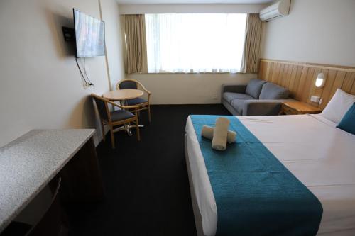 a room with a bed with a teddy bear on it at Citigate Motel Newcastle in Newcastle