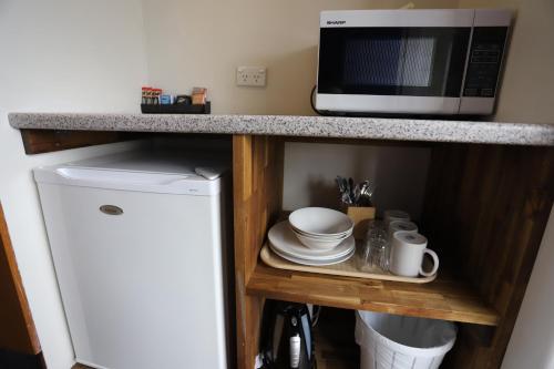 a kitchen with a microwave and a small refrigerator at Citigate Motel Newcastle in Newcastle