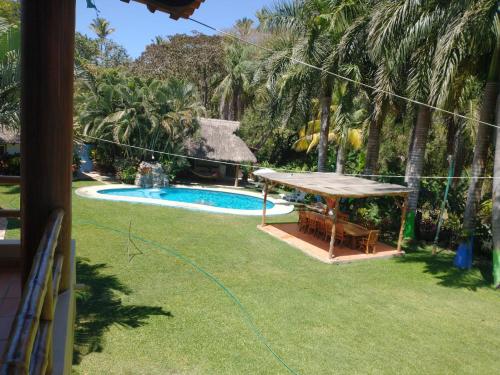 un patio trasero con cenador y piscina en Hacienda Jaqueline, en Sayulita