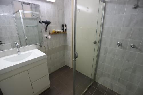 a bathroom with a glass shower and a sink at Citigate Motel Newcastle in Newcastle