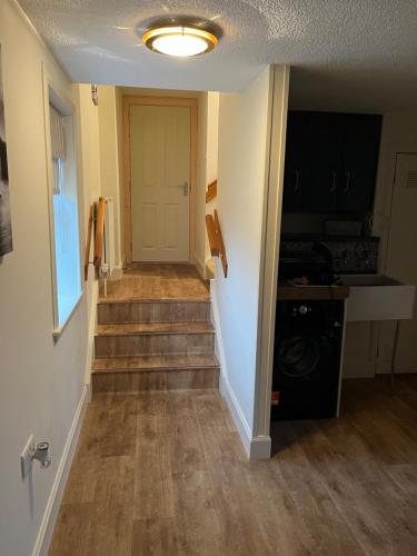 a hallway of a house with stairs and a door at Pentland view croft with a sea view in Melvich