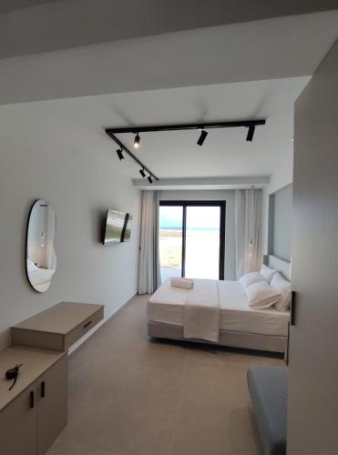 a white bedroom with a bed and a mirror at Onar in Sarti in Sarti
