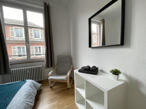 a bedroom with a mirror and a bed and a chair at Chambres privées -Private room- dans un spacieux appartement - 100m2 centre proche gare in Mulhouse