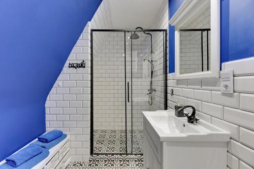 a white bathroom with a shower and a sink at Pola by Q4Apartments - heart of the Old Town in Gdańsk